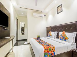 a bedroom with a large bed and a flat screen tv at Hotel Rachna Tourist lodge in New Delhi