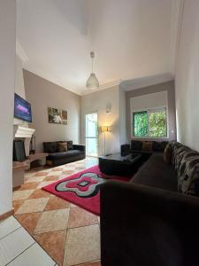 a living room with a couch and a red rug at Spacious appartment in center harhoura in Temara