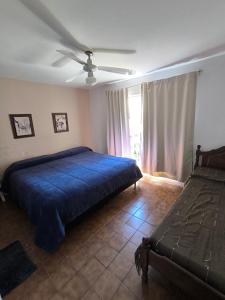 ein Schlafzimmer mit einem blauen Bett und einem Fenster in der Unterkunft Casa Milu in Mina Clavero
