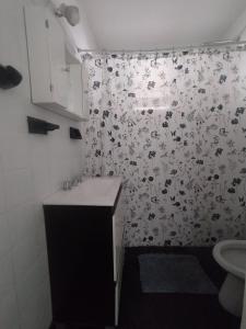 ein Bad mit einem Duschvorhang mit einem Waschbecken in der Unterkunft Casa Milu in Mina Clavero + 2 Fotos