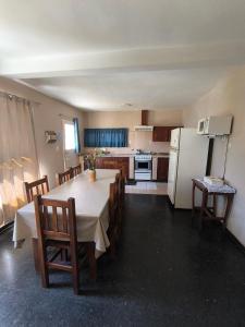 eine Küche mit Tisch und Stühlen und einem Kühlschrank in der Unterkunft Casa Milu in Mina Clavero