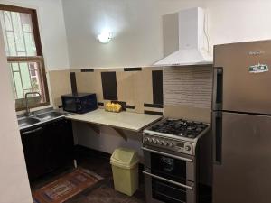 a small kitchen with a stove and a sink at Two Bedroom Apartment- Senegambia Kololi- Kerr Ayo in Serekunda