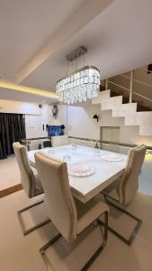 a dining room with a white table and chairs at 3 bedroom Shreeji's Viila with Private pool in Lonavala