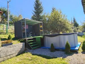 a tiny house in a yard with a shed at Садиба 'Віраж' in Vorokhta