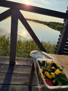 un vassoio di verdure su un tavolo con vista sull'acqua di Pirtelė ant tvenkinio kranto a Pamarys