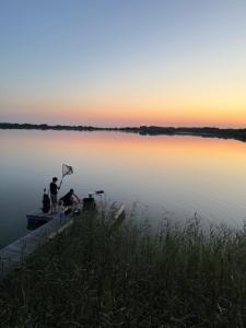 due persone su un molo su un lago al tramonto di Pirtelė ant tvenkinio kranto a Pamarys Altre 2 foto
