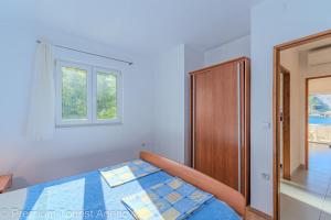 a bedroom with a bed and a window at Podvornica in Metajna