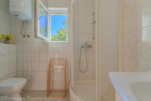 a bathroom with a shower and a toilet and a sink at Podvornica in Metajna