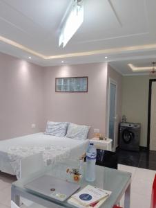 a white bedroom with a bed and a table at Nice apartment in Menzah 5 in Ariana