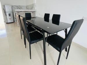 a black dining room table with black chairs at Apto con piscina a 7 min caminando de playa Bello Horizonte in Santa Marta +14 photos