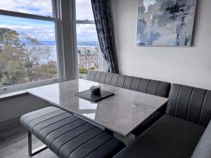 a table and a bench in a room with a window at Abhaille Chluaidh - Macaulay Letting in Helensburgh