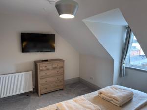 a bedroom with a bed and a tv on the wall at Abhaille Chluaidh - Macaulay Letting in Helensburgh