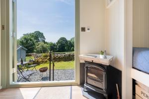a bathroom with a door open to a view of a yard at Percy Shepherd's Hut - High Borrans Farm in Ings