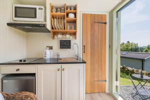 a kitchen with a microwave and a counter top at Percy Shepherd's Hut - High Borrans Farm in Ings