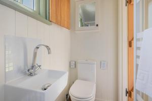 a bathroom with a white toilet and a sink at Percy Shepherd's Hut - High Borrans Farm in Ings