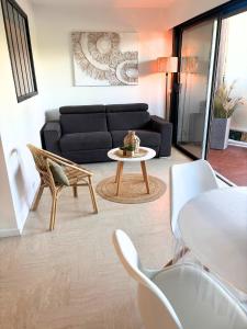 a living room with a couch and a table and chairs at Studio cosy avec piscine Mandelieu La Napoule in Mandelieu-la-Napoule