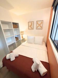 a small bedroom with two towels on a bed at Studio cosy avec piscine Mandelieu La Napoule in Mandelieu-la-Napoule