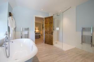 ein Badezimmer mit einer weißen Badewanne und einer Glasdusche in der Unterkunft Atherstone Farmhouse and Cottage in Stocklinch + 31 Fotos