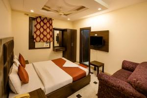 a hotel room with a bed and a couch at Hotel Vishesh Continental Karol Bagh in New Delhi