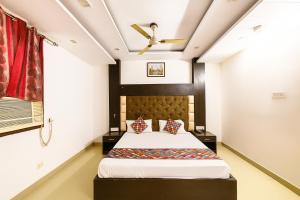 a bedroom with a bed and a ceiling fan at Hotel Vishesh Continental Karol Bagh in New Delhi