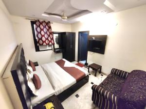 a bedroom with a bed and a couch in it at Hotel Vishesh Continental Karol Bagh in New Delhi