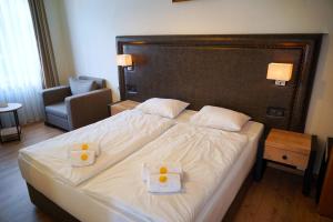 a bedroom with a large bed with two towels on it at Hotel Sonne in Todtnau +6 photos