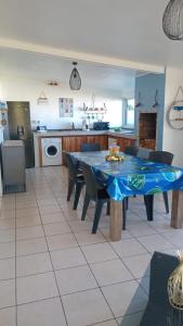 a kitchen with a blue table and chairs in a room at Chez Fannie et Alain in Saint-Paul
