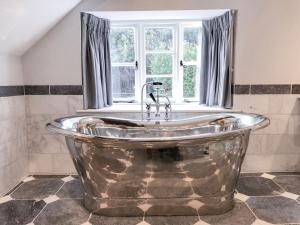 eine große Metallbadewanne im Bad mit Fenster in der Unterkunft Orchard Cottage in Stocklinch + 32 Fotos