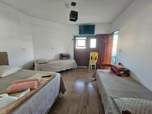 a room with three beds and a chair in it at Pousada e Galeria Mestre dos Magos in São Thomé das Letras +14 photos