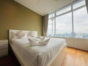 Un dormitorio con una cama blanca con una ventana grande. en Sky Suites KLCC By Elite Stay, en Kuala Lumpur