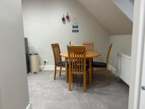 Un comedor con mesa y sillas de madera. en The Attic Portpatrick, en Portpatrick