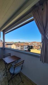 a balcony with a table and a chair and a window at Modern Loft in Torre del Lago Puccini