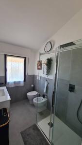 a bathroom with a toilet and a glass shower at Modern Loft in Torre del Lago Puccini