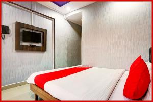 a bedroom with a bed with red pillows and a tv at Hotel Madison Blue Near Railway Station -Fully Air Conditioned Room-Hygiene And Spacious Room - A Premium Hotel in Bhubaneshwar