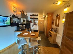 eine Küche mit Tisch und Stühlen in einem Zimmer in der Unterkunft CHAMONIX Centre - Studio de charme avec parking, Vue sur le Mont-Blc in Chamonix-Mont-Blanc