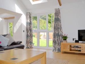a living room with a couch and a window at Swallow Barn-Ow2 in Saint Twynnells