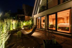 a patio with a chair in front of a building at Alva Rhön Panorama Ferienhaus - Auszeit mit Kamin in Frankenheim