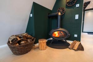 a wood fired stove with a basket of logs at Alva Rhön Panorama Ferienhaus - Auszeit mit Kamin in Frankenheim