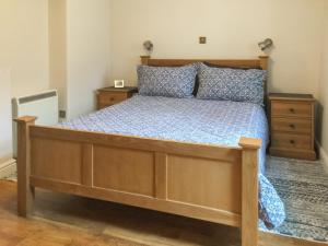 a bedroom with a bed with a wooden bed frame at The Bothy in Bradworthy +9 photos
