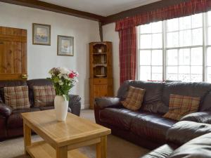 Una sala de estar con un sofá y una mesa con flores. en Belfrey House, en York