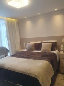 a bedroom with a large bed and a window at Apartamento moderno centro de Gramado in Gramado +30 photos