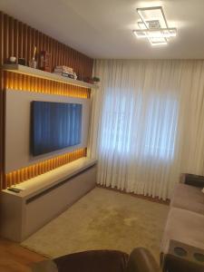 a living room with a large flat screen tv on a wall at Apartamento moderno centro de Gramado in Gramado