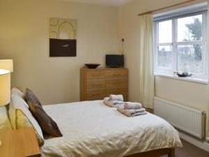 ein Schlafzimmer mit einem Bett mit Handtüchern darauf in der Unterkunft Abbey Cottage in Longhirst + 11 Fotos