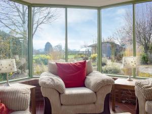 a living room with a chair and a large window at Meadow View in Harley
