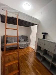 a room with a bunk bed with a desk and a couch at Appartement in Montreuil