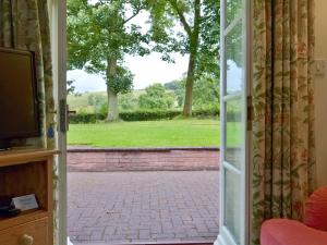an open door with a view of a yard at Garden Farm Cottage in Ilam