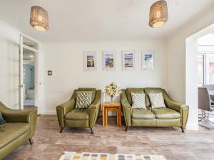 a living room with two chairs and a table at The Beach Bungalow in Beltinge