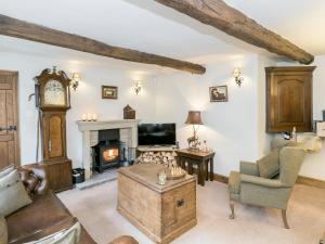 a living room with a fireplace and a grandfather clock at Narrowgates Cottage in Barrowford