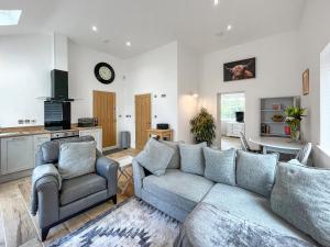 a living room with a couch and two chairs at Wyn Shiels Hide Away in Ainstable