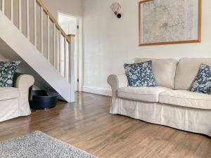 a living room with a couch and a staircase at Holmfield in Buxton
